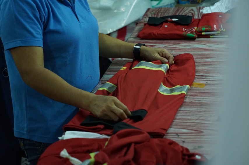 A Sinaya team member finishing a safety garment